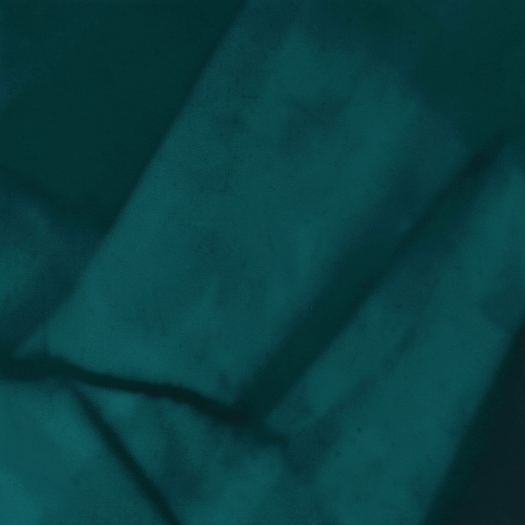 A duotone photograph in deep teal and warm cream tones showing a stylish flat lay of clothing accessories and beauty items, arranged neatly with a calm, elegant mood